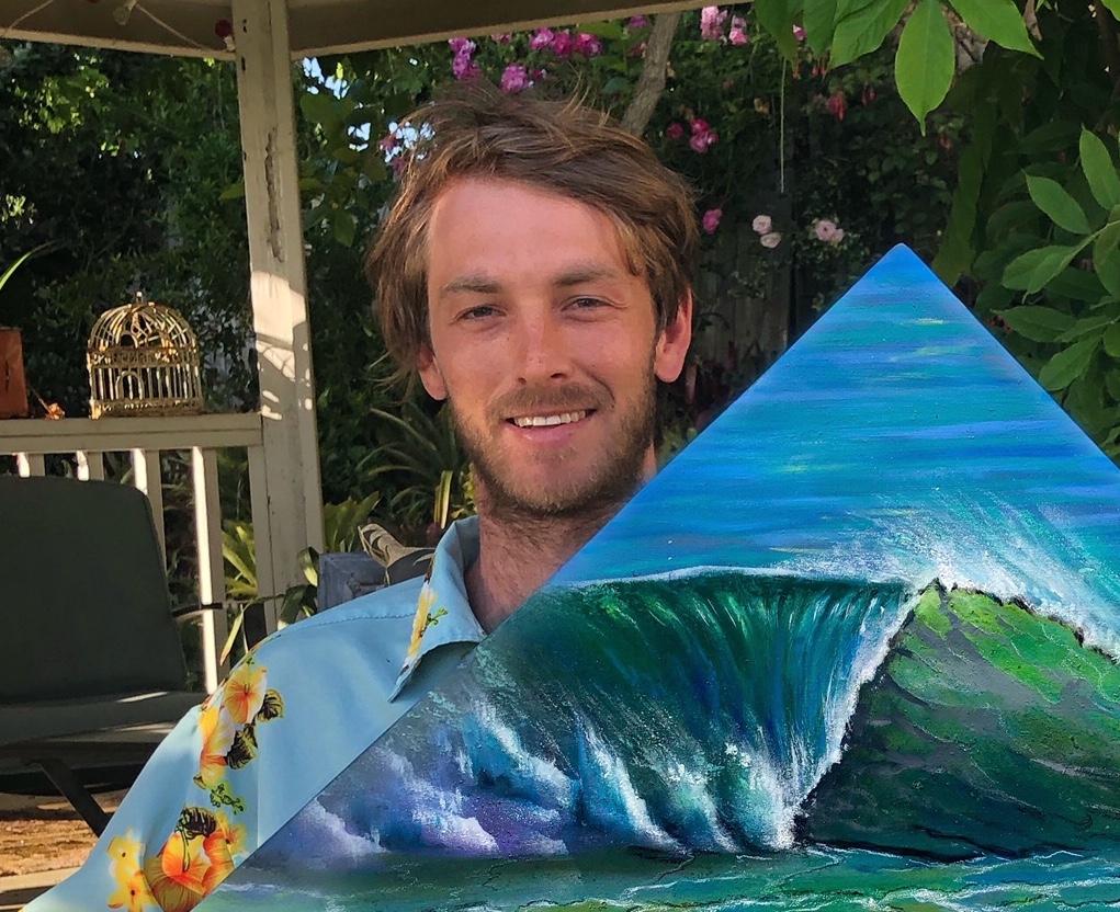 Headshot of Trevor Coopersmith with pyramid shaped painting of a crashing wave