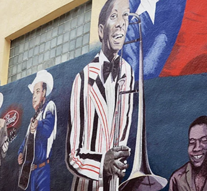 Mural of a Blues band playing instruments in front of a Texas flag.