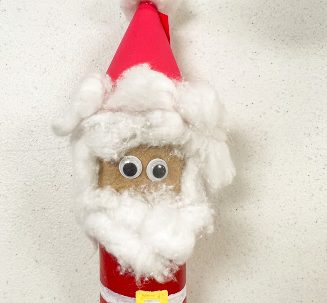 Toilet paper roll decorated with construction paper, paint, cotton and googly eyes to look like Santa Claus
