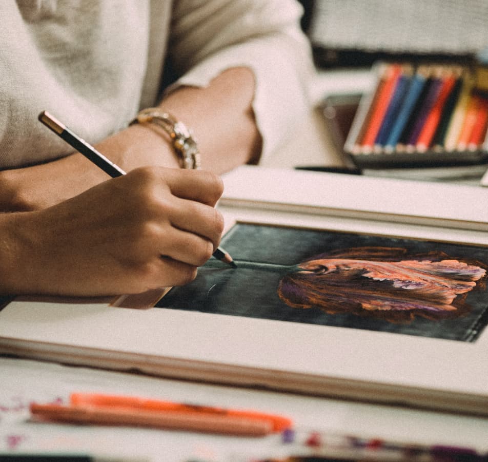 Up close photo of a person drawing a detailed, colored pencil, illustration of a pink tulip