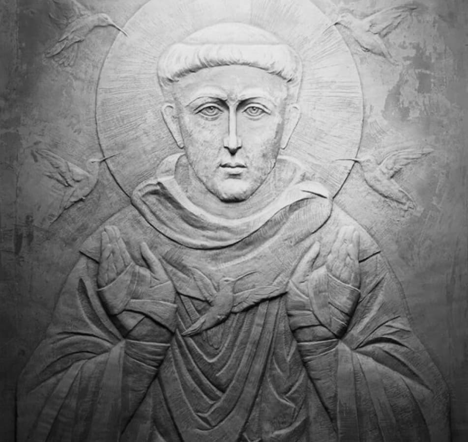 Relief sculpture of a man dressed in robes, his head surrounded by a halo of light while humming birds are flying behind him
